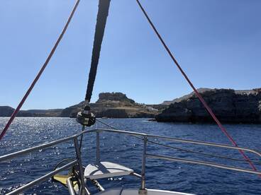 A scenic view from the deck of a boat, showcasing the coastline and cliffs in the background — perfect for exploring beautiful marine landscapes.