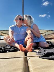 A couple shares a romantic moment on a boat, enjoying the sunny weather and each other's company — perfect for intimate getaways on the water.