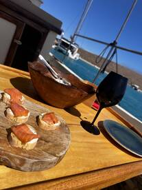 A beautifully arranged platter of salmon appetizers and a glass of wine on a boat, perfect for a relaxing day at sea.