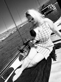 A woman enjoys a glass of wine while relaxing on the deck of a yacht, embodying the perfect atmosphere for a leisurely day on the water.