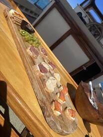 A beautifully arranged charcuterie board featuring assorted meats, cheeses, and fresh grapes, perfect for enjoying on a boat trip.