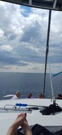 Guests enjoy a relaxing moment aboard a boat, with stunning ocean views and a cloudy sky, perfect for a day on the water.