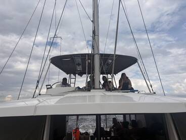 A lively group enjoys their time aboard a catamaran, showcasing the fun and camaraderie of a boating adventure.
