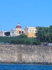 A picturesque view of a historic building along the coastline, showcasing the beauty of the landscape and architecture — perfect for sightseeing during boat tours.