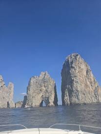 A stunning view of iconic rock formations at Cabo San Lucas, with a boat navigating through the scenic waters — a perfect destination for sightseeing and exploration.