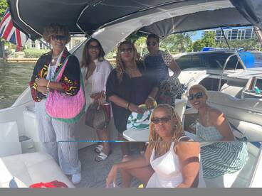A vibrant group of friends enjoys a sunny day on a boat, showcasing the perfect setting for celebrations and memorable outings on the water.