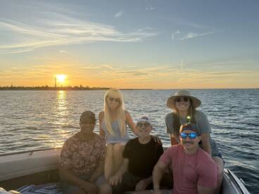 A cheerful group enjoys a sunset on a pontoon boat, capturing a perfect moment of camaraderie and celebration on the water.
