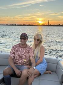 A couple enjoys a romantic sunset on a boat, capturing a perfect moment of togetherness against a stunning backdrop.