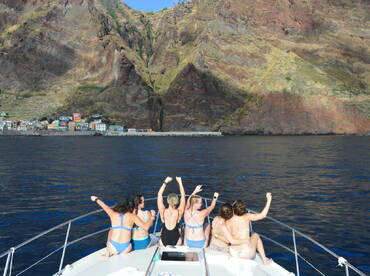 A group of friends enjoys a scenic boat ride, celebrating against a stunning coastal backdrop — perfect for memorable outings and adventures on the water.