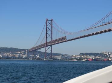 A stunning view of the iconic bridge against a clear blue sky, showcasing the beautiful scenery of the waterfront and surrounding landscape — perfect for sightseeing tours.