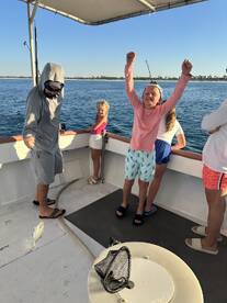 A joyful moment on a fishing trip as kids celebrate their catch aboard the boat, showcasing the excitement of family fishing adventures.