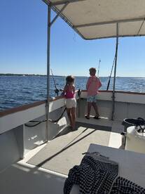 Two children enjoy a fishing experience on a boat, creating memorable family moments on the water.