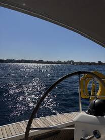 A view from the helm of a boat, showcasing the sparkling water and distant shoreline — perfect for those who enjoy navigating the open seas.
