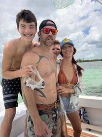A joyful family poses for a fun photo on a boat, ready for a snorkeling adventure in beautiful waters. Perfect for capturing memorable moments on the water.