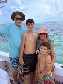 A joyful family poses together on a boat, ready for a day of snorkeling and adventure in the beautiful waters.