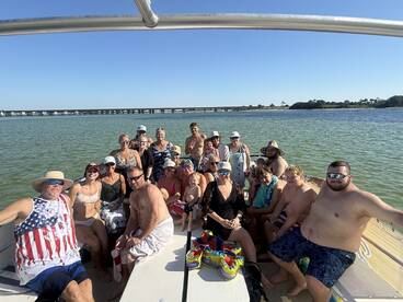 A lively group of friends and family enjoy a fun day on the water, celebrating together aboard a boat. Perfect for memorable gatherings and summer outings.