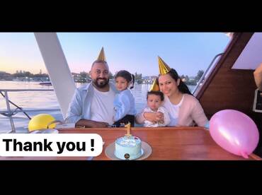 A joyful family celebrates a birthday aboard a boat, complete with a festive cake and party hats, creating cherished memories on the water.
