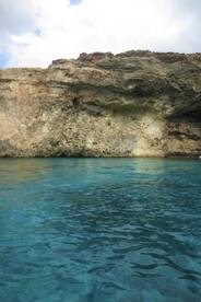 A stunning view of a rocky coastline reflected in the clear turquoise waters, perfect for capturing the natural beauty of the area.