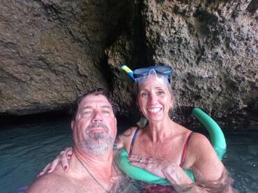 A couple enjoys snorkeling in a scenic cave, showcasing a fun underwater adventure perfect for exploring marine life.