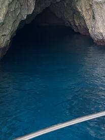 An unclear view of a cave entrance with dark waters, creating an intriguing yet ambiguous scene.
