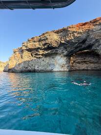 Two snorkelers explore the crystal-clear waters near stunning rock formations, capturing the essence of a perfect day on the water.