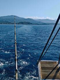 A scenic view from a fishing boat, showcasing the tranquil ocean and distant mountains — perfect for fishing enthusiasts and nature lovers.
