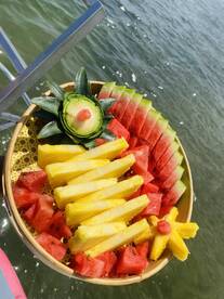 A beautifully arranged platter of fresh fruit, including watermelon and pineapple, perfect for enjoying on a boat trip or during a sunny day on the water.