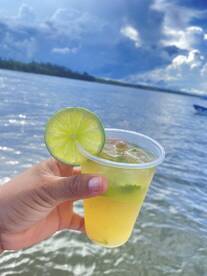 A refreshing cocktail garnished with lime, perfect for enjoying on a sunny day by the water. Ideal for boat trips or beach outings.