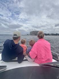 A family enjoys a scenic view from the bow of their boat, creating cherished memories together on the water.