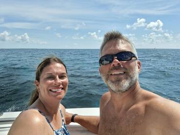 A couple enjoys a sunny day on the ocean, capturing a joyful selfie while out on the water — perfect for memorable boating adventures.