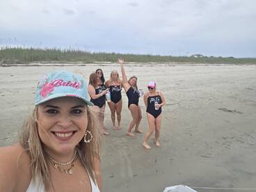 A fun group of friends celebrates a beach party, with the bride-to-be in the spotlight, making for a memorable pre-wedding celebration.