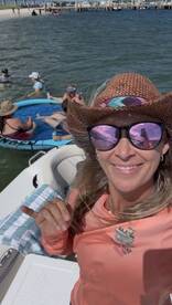 A lively group enjoys a fun day on the water, with friends relaxing on a floating mat and swimming nearby — perfect for summer adventures.