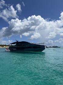 A sleek yacht docked in clear turquoise waters under a bright blue sky, showcasing the perfect setting for luxurious boating adventures.
