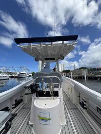 An interior view of a boat's helm with a captain seated, showcasing the sleek design and functionality of the vessel's console.