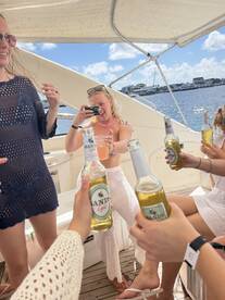 A lively group of friends enjoys drinks and captures memories aboard a boat, perfect for celebrations and fun outings on the water.