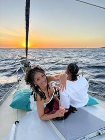 A couple enjoys a romantic sunset on a yacht, toasting with cocktails and celebrating their special moment on the water.