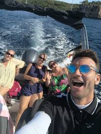 A joyful group of friends enjoys a fun day on the water, capturing memories with smiles and laughter aboard their boat.