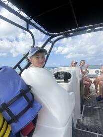 A young boy enjoys a day on the boat with family, capturing the essence of fun and adventure on the water.