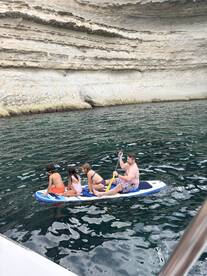 A family enjoys paddleboarding together in calm waters, creating unforgettable memories on their aquatic adventure.