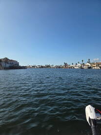 A picturesque view of a tranquil waterway lined with palm trees and waterfront homes, perfect for a relaxing day on the water.