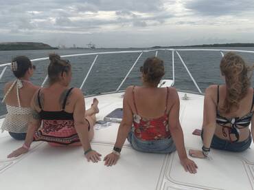 A group of friends enjoys a relaxing moment on the deck of a boat, taking in the scenic ocean views — perfect for a day out on the water.