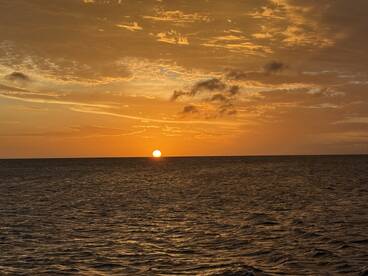 A stunning sunset over the ocean, creating a picturesque backdrop for evening boat cruises or tranquil moments on the water.