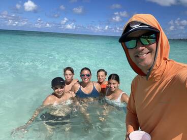 A joyful family enjoys a fun day swimming in the clear turquoise waters, creating unforgettable memories together at the beach.