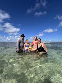 A joyful family enjoys a fun day in shallow waters, creating lasting memories together under the sunny sky.