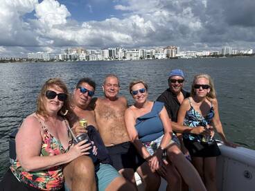 A cheerful group of friends enjoys a day on the water, capturing the essence of fun and relaxation while boating in a scenic setting.