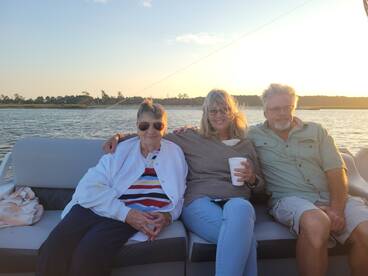 A joyful group enjoys a sunset cruise on a boat, capturing a moment of togetherness and celebration on the water.