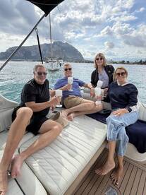 A cheerful group enjoys cocktails aboard a yacht, surrounded by stunning coastal views — perfect for memorable gatherings on the water.