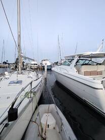 A serene view of multiple yachts docked at a marina, showcasing their sleek designs and tranquil surroundings.