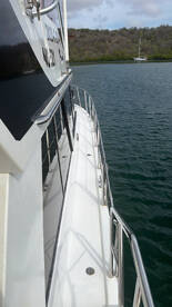 A close-up view of the side of a boat, showcasing its sleek design and structure against a tranquil water backdrop.