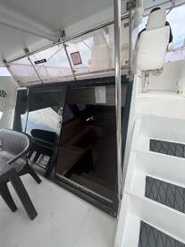 Interior view of a boat cabin featuring seating and access stairs, showcasing a comfortable space for relaxation on the water.